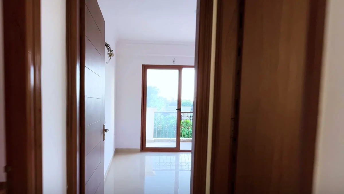 Polished vitrified floors and teak-finish doors inside a finished apartment